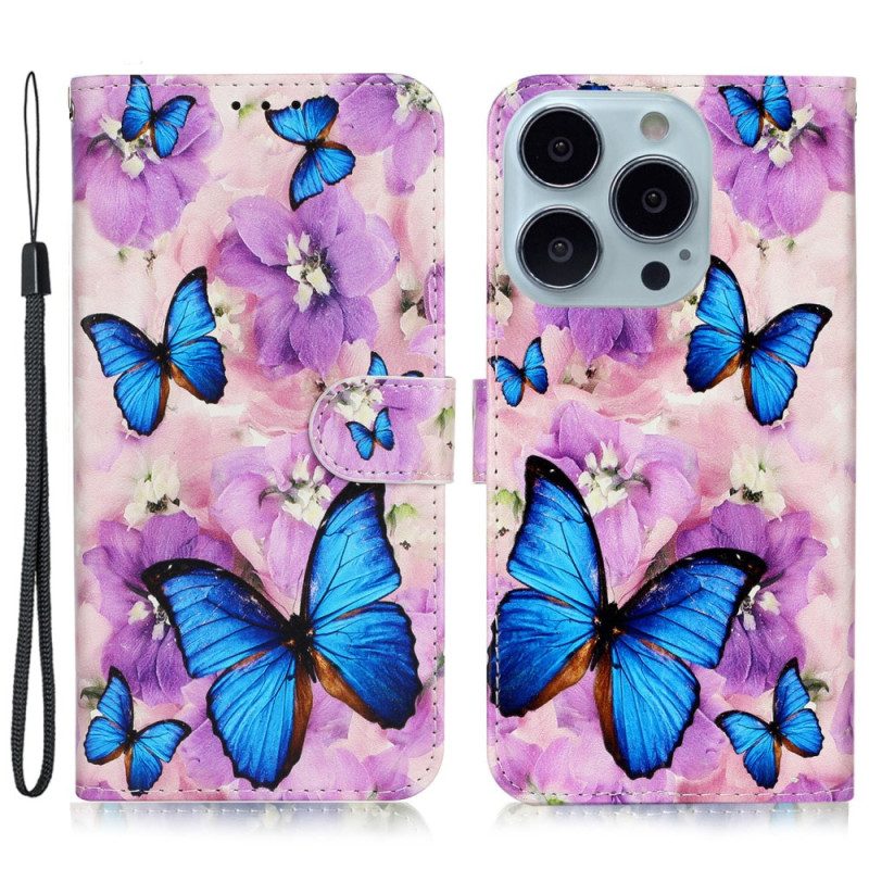 Folio-hoesje iPhone 16 Pro Telefoonhoesje Blauwe Vlinders En Paarse Bloemen Met Riempje